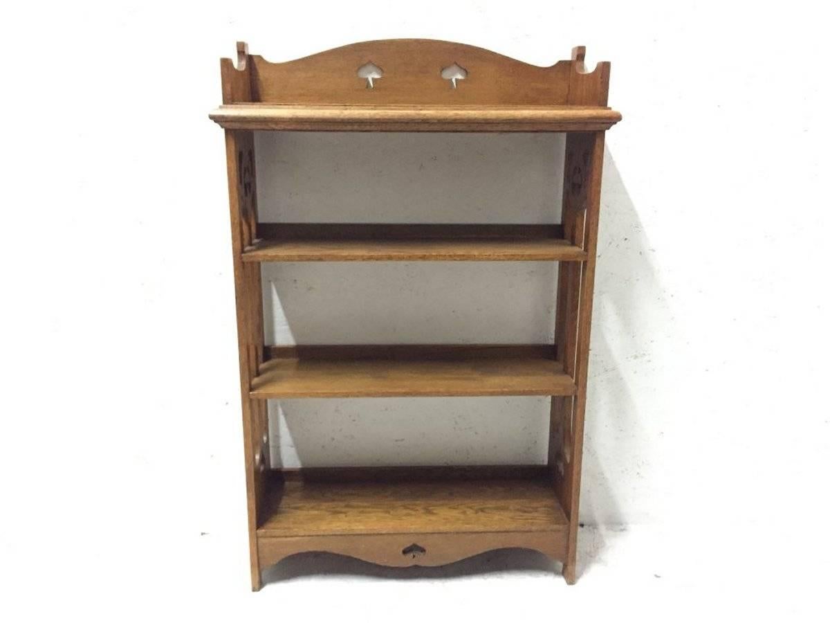 Liberty & Co attributed. An Arts and Crafts oak bookcase, with stylized floral cut-outs and floral fretwork side details.