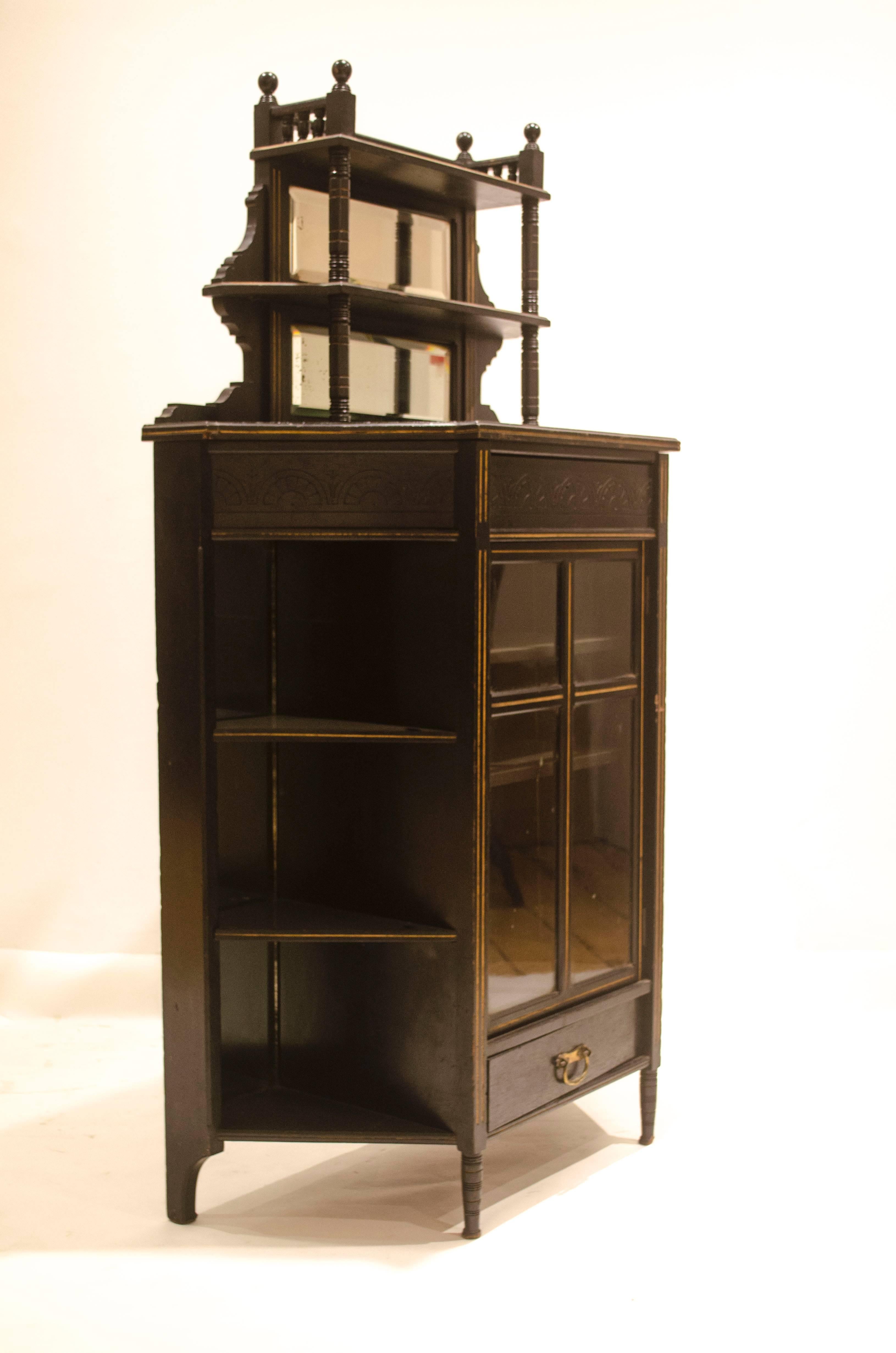 Edward William Godwin made by William Watt, with applied enamel label.
An Important Anglo-Japanese ebonised display cabinet with an upper and lower drawer, the upper drawer a secret drawer concealed behind the carved central half