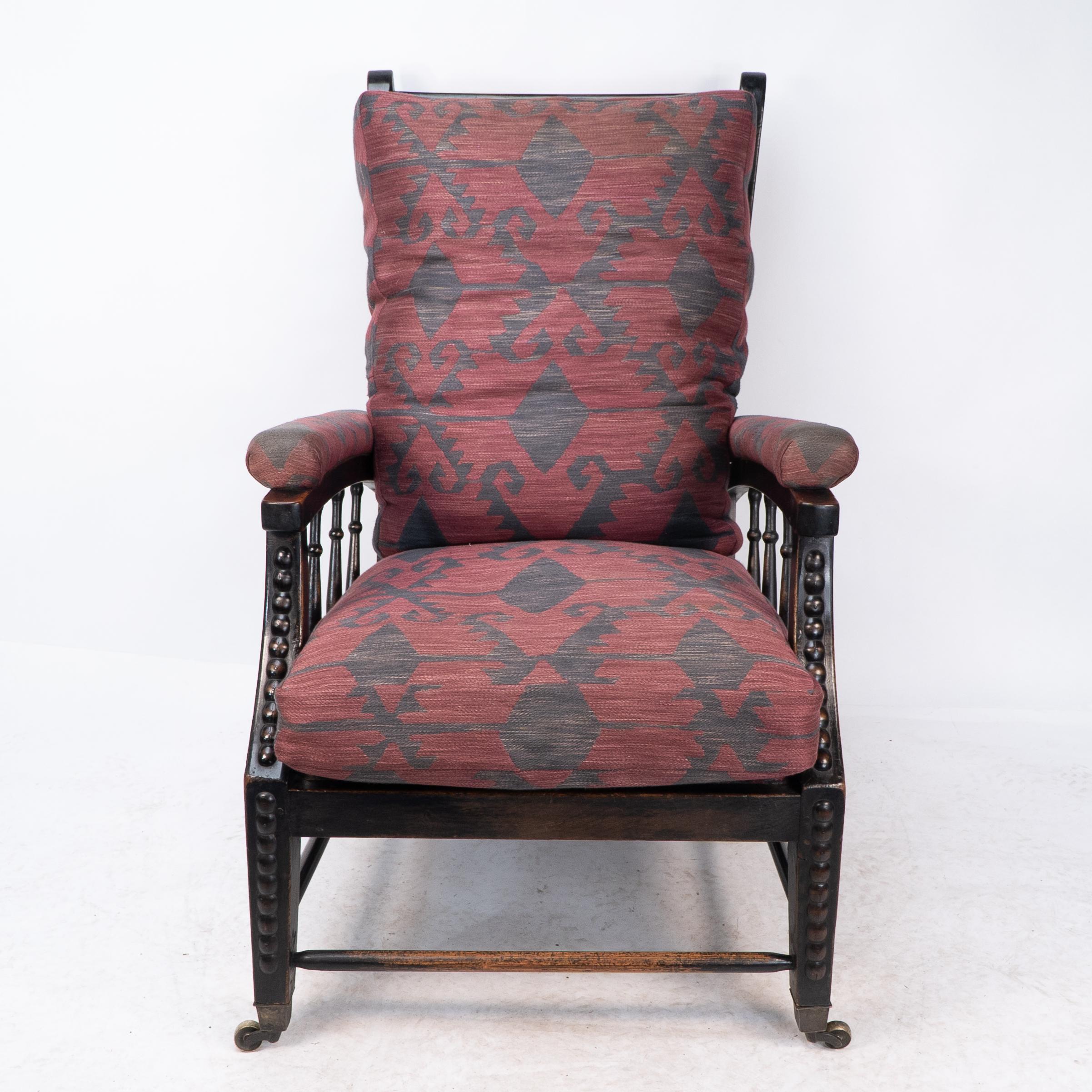 Phillip Webb for Morris and Co. Designed in C1866.
A rare Aesthetic Movement ebonized adjustable reclining armchair. The arched arms with padded armrests united to the sweeping arched legs by turned uprights, with adjustable reclining shaped back.