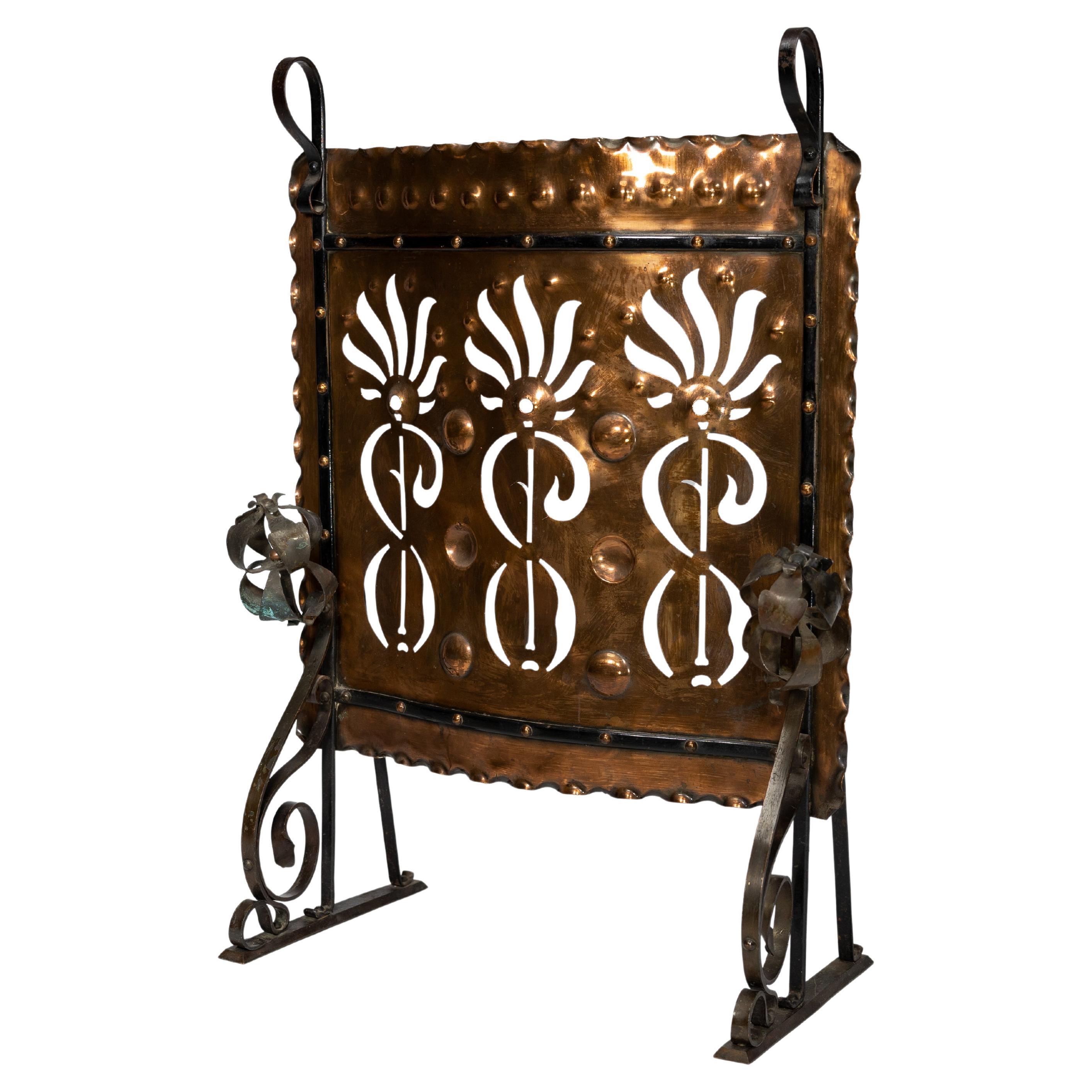 Liberty & Co. An Arts & Crafts wrought iron & copper pierced floral firescreen.