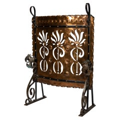 Antique Liberty & Co. An Arts & Crafts wrought iron & copper pierced floral firescreen.
