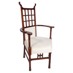 Antique Liberty & Co probably made by William Birch. An Arts & Crafts mahogany armchair.