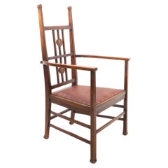 Liberty and Co. attributed. An Arts & Crafts walnut armchair with floral inlays.
