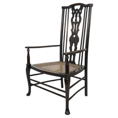 Liberty & Co attributed. A Queen Anne style fretwork back cane seat armchair.
