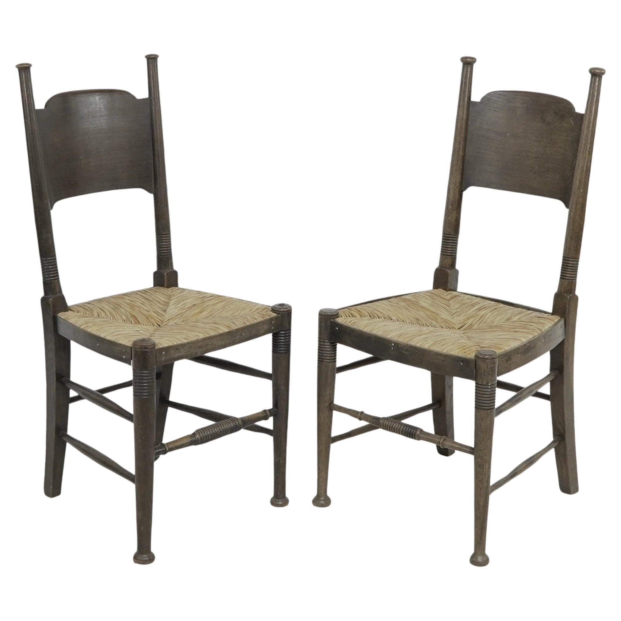 William Birch, retailed by Liberty & Co. Pair of Arts & Crafts oak dining chairs
