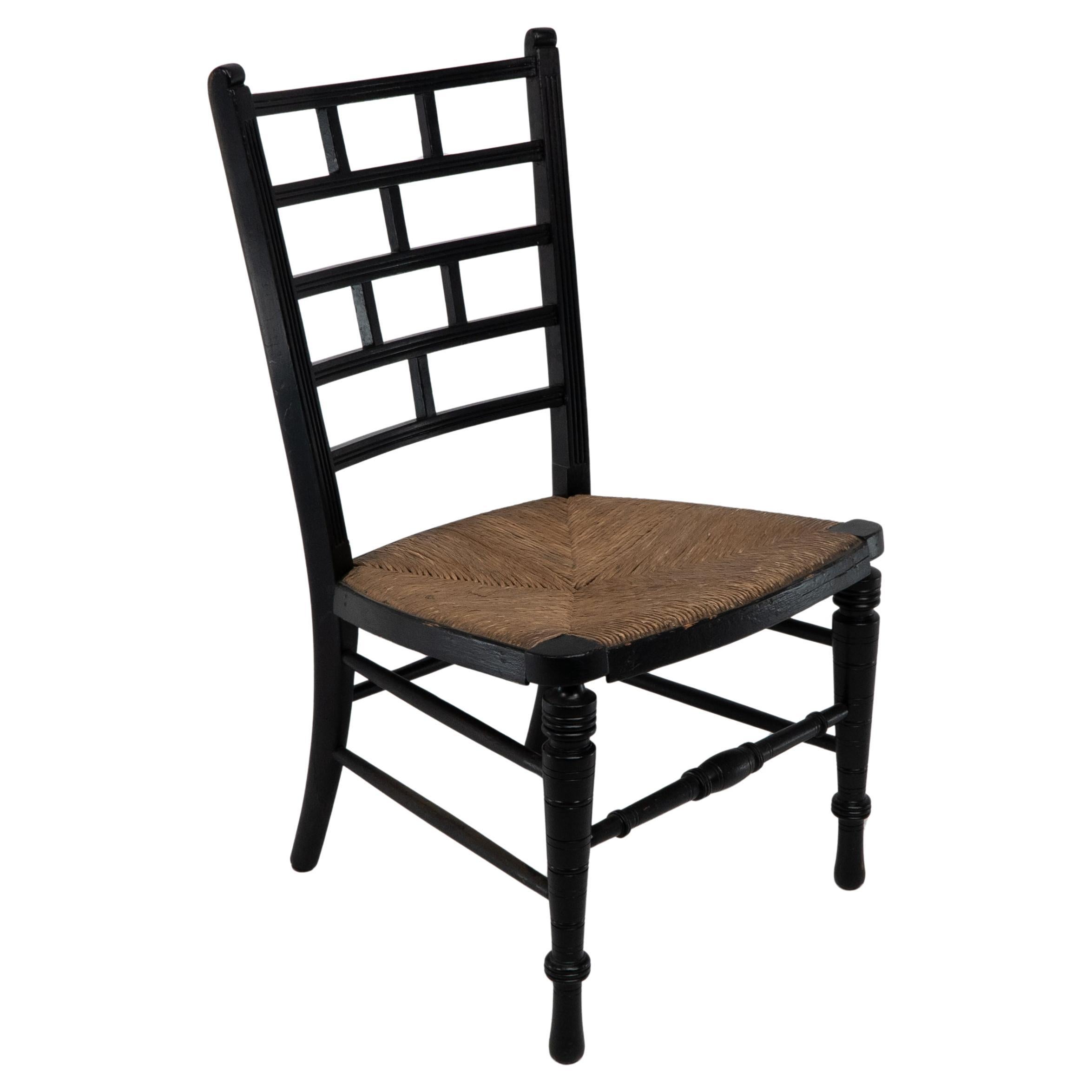 E W Godwin (style of). An Anglo-Japanese rush seat ebonized side chair For Sale