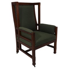 Antique Liberty and Co, attr. in the style of Leonard Wyburd. An oak wing back armchair