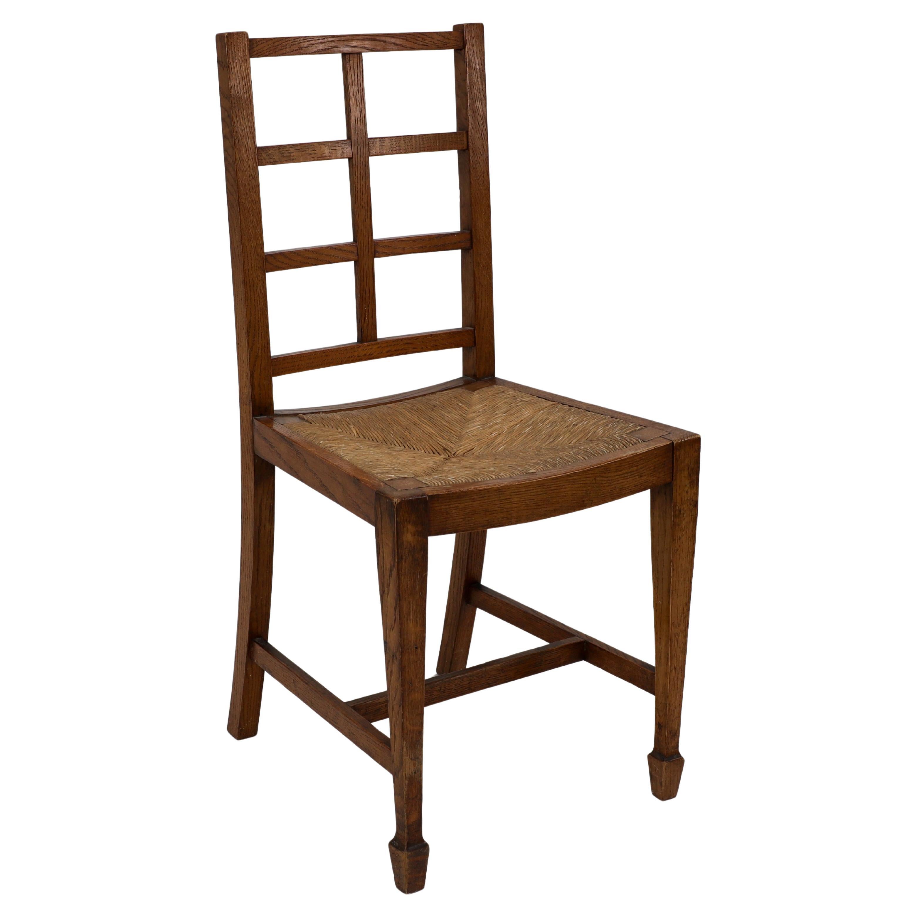 Heals of London, attributed. An Arts & Crafts oak lattice back side chair