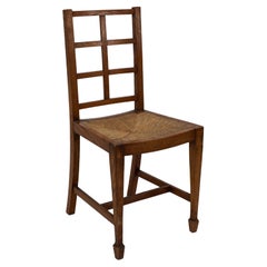 Heal's di Londra, attribuito. Una poltrona con schienale a traliccio in rovere Arts & Crafts