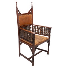 Antique Liberty & Co. A Moorish Arts & Crafts walnut armchair with original leather seat