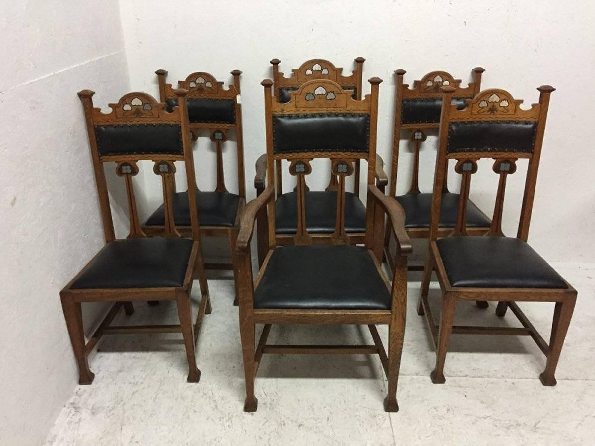 A rare set of six Arts and Crafts chairs attributed to Liberty and Co with stylized floral inlays using Pewter Ebony and fruit woods.