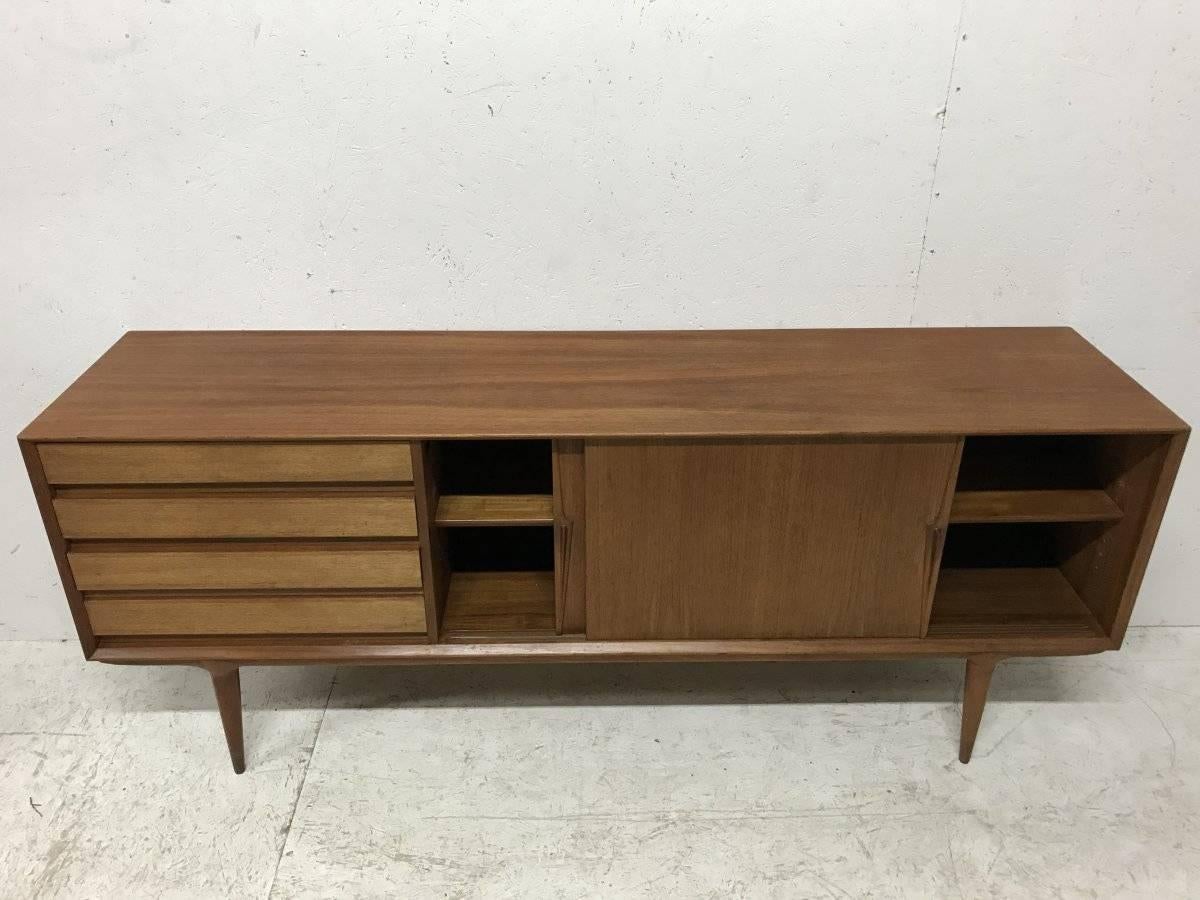 A rare Model 18 teak sideboard having four drawers and two sliding doors to the cupboard, on rounded and tapered legs.