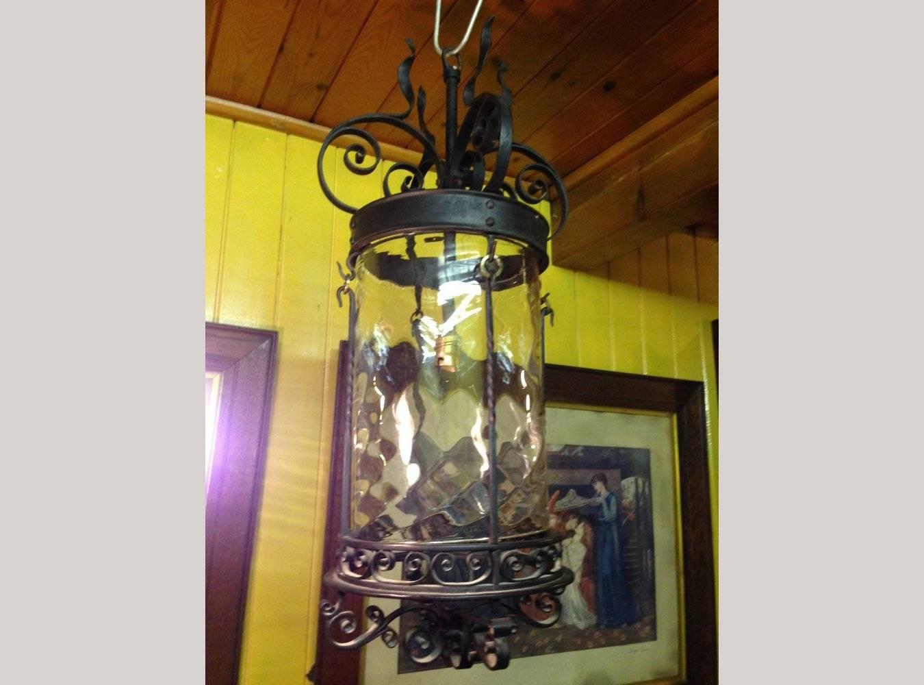 An Arts & Crafts hand wrought iron lantern with flaming tendrils retaining the original dappled shade..

 