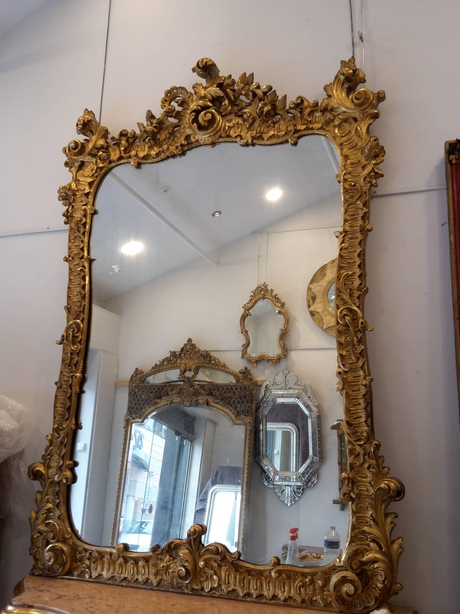 French mirror and console table giltwood in a Louis XV style Baroque inspiration, carved wood with voluptuous motifs and acanthus flowers, marble top with little cracks, made in Napoléon III in France, circa 1860-1870.