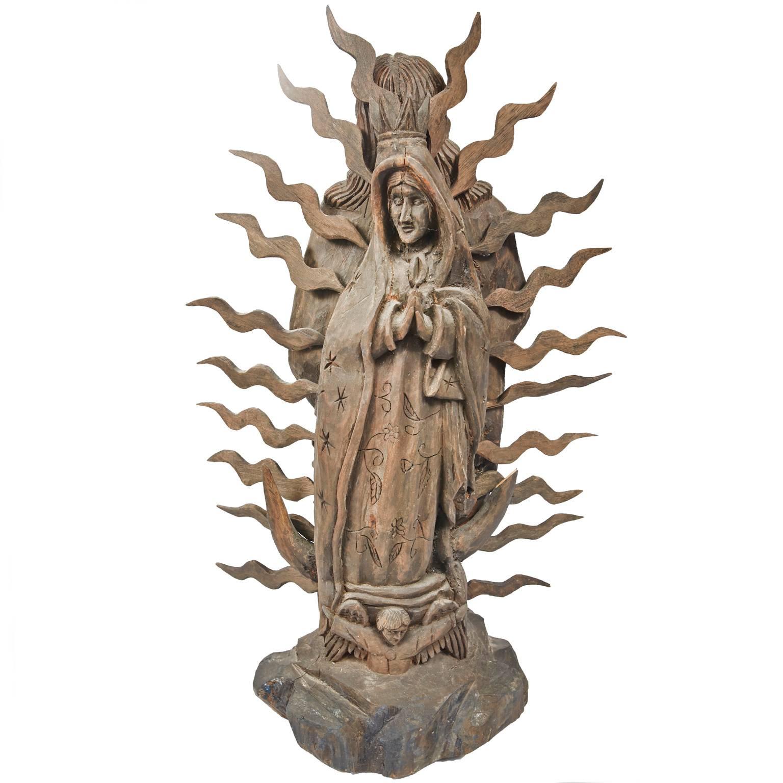 Unique two-sided hand-carved statue depicting the Sacred Heart of Jesus and the other side, The Virgin of Guadalupe. Removable carved pieces of wood surround the statue.