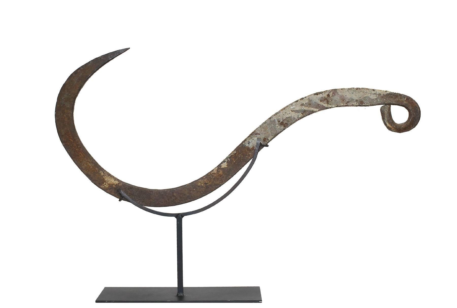 These kinds of hooks were used to load old cargo ships. The hooks would be used to grasp large nets made of rope and load onto large sail ships. This piece is mounted on a Stand and is an usual conversation piece. Large hook with a great patina