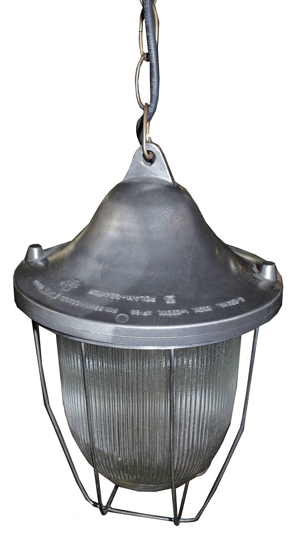 Original antique pendant light. Wonderful ribbed glass and stylish caged lines.
Heavy iron top, stripped and clear coated finish. Functional and stylish, great over and island or in an entryway.