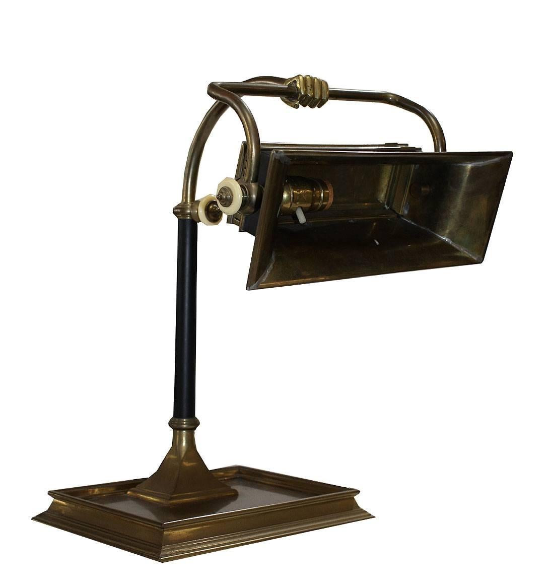 Brass banker lamp with brass fist. Works well single switch under the hood. Hood moves freely, heavy weight with solid base. Unique and stylish this is a wonderful lamp for a traditional desk or library piece.