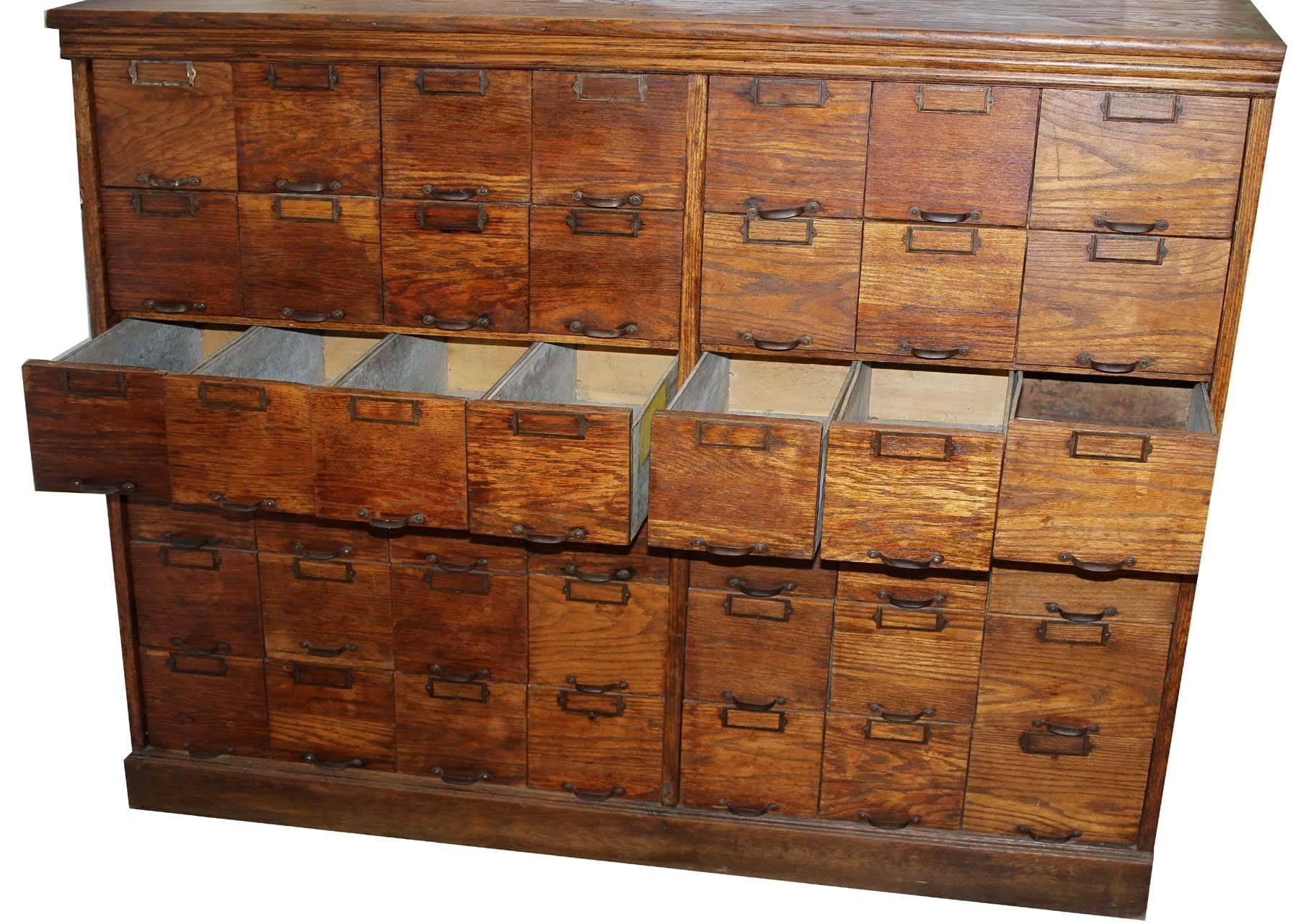 This item was originally used to store seeds for sale at an old country store. Tin lined drawers and oak drawer front. All original fixtures including the caption brackets for description cards to be inserted for easy identification of each drawer.