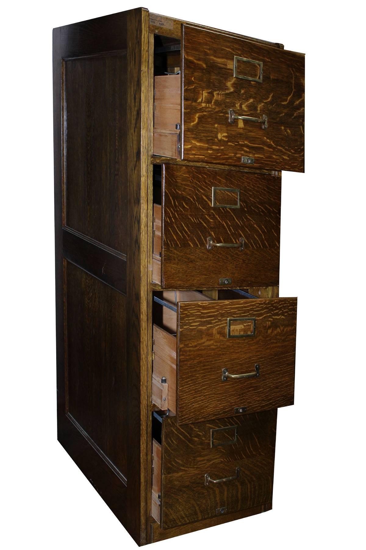 Impeccable quarter sawn oak filing cabinet with brass trim. Four large draws for full size files. This is old school class, an elegant way to store files. Each drawer has a metal frame for contemporary hanging files. The cabinet is finished in