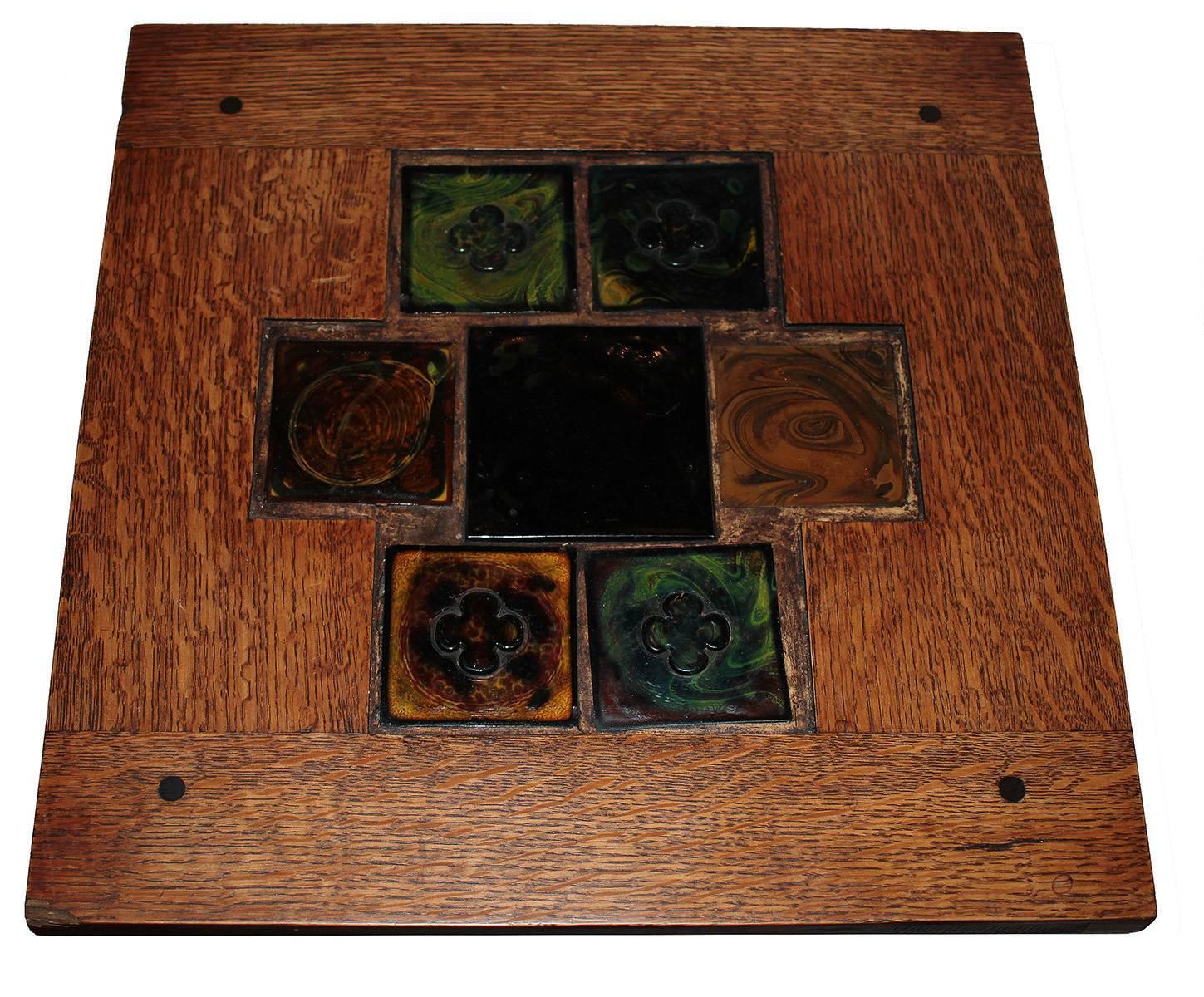 A beautiful oak mission end table with handmade inset tiles. This is an original unsigned piece that has all the hallmarks of Classic American Arts and crafts movement. Solid quarter saw oak with a perfect patina. There are four colorful inset tiles