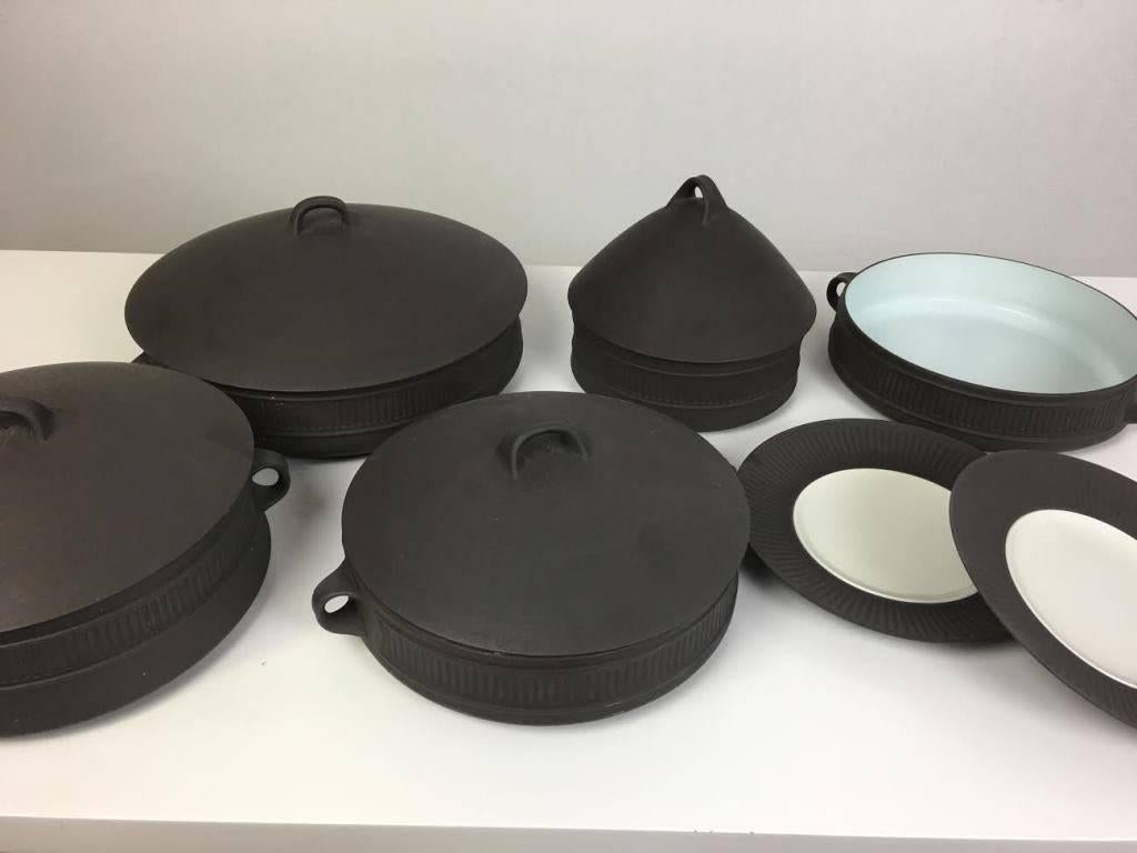 This Classic Mid-Century stoneware was designed by Jens Harold Quistgaard for Dansk in 1963, and while Dansk has reissued this pattern, these items are vintage. Deep matte grey brown with a white glazed center.
11 pieces total.

Marked on the