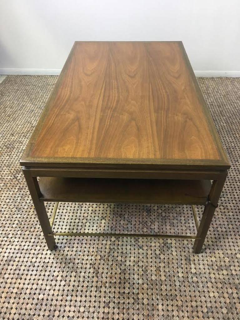 Edward Wormley A1012 plateau cocktail table, manufactured for Dunbar. Two-tone wood top, lower shelf and brass stretchers.
Brass Dunbar plaque.

A fine addition to any setting, mid-century or otherwise.

Dimensions: 22