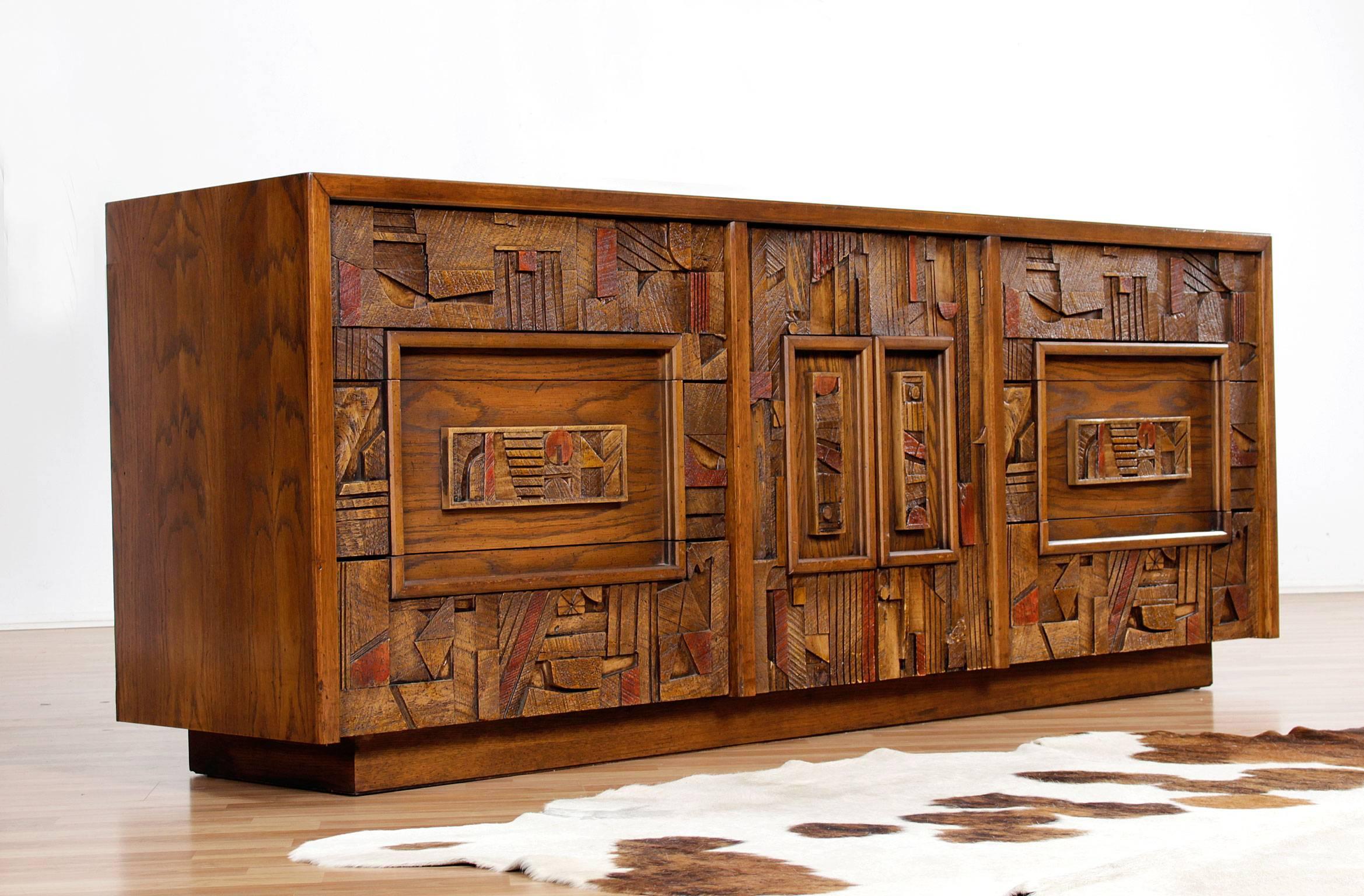 A vintage, 1970s, Lane Brutalist triple dresser with an intricately laid, highly textured pattern that adorns the front facade. The rough hewn forms exemplify the Brutalist aesthetic. Center door conceals a column of three drawers. Ample storage