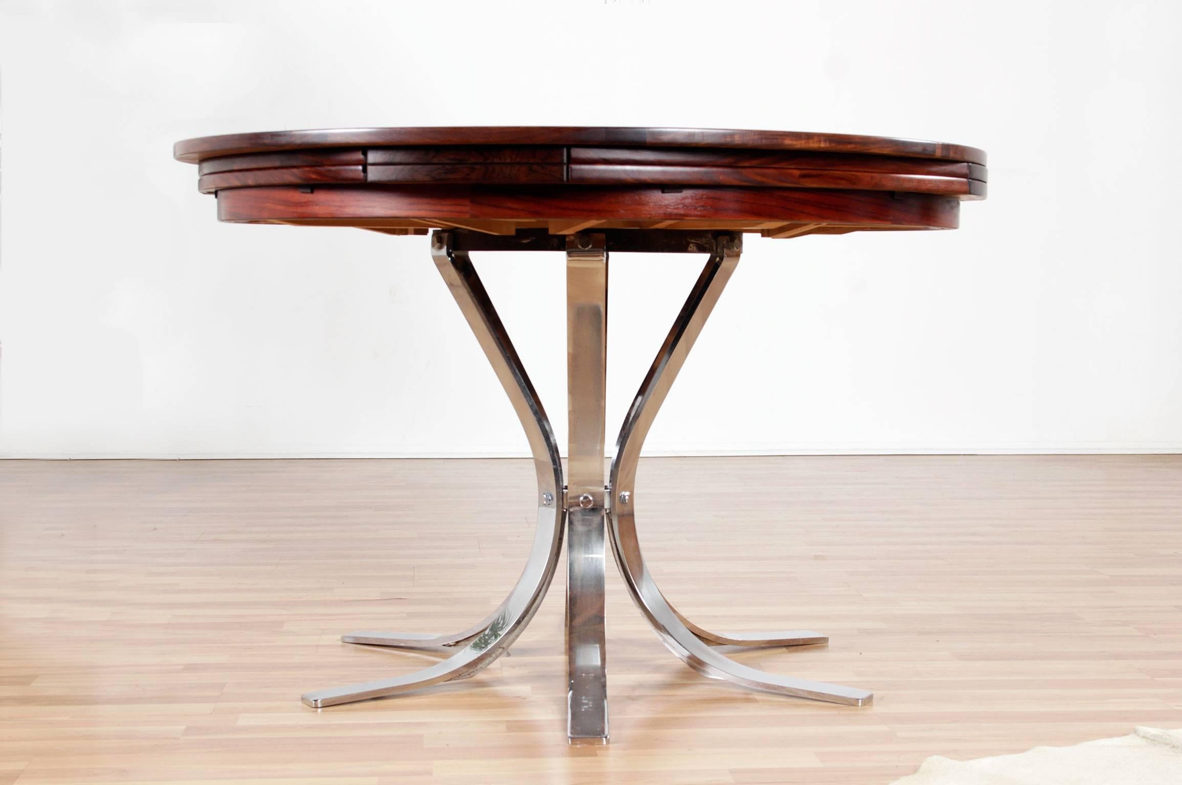 Stunning heirloom quality mid-century modern "Flip Flap Table" by Dyrlund. Made in Denmark with luxurious rosewood table top and sleek chromed steel pedestal base. The table bears the original maker's mark beneath the table top. What makes