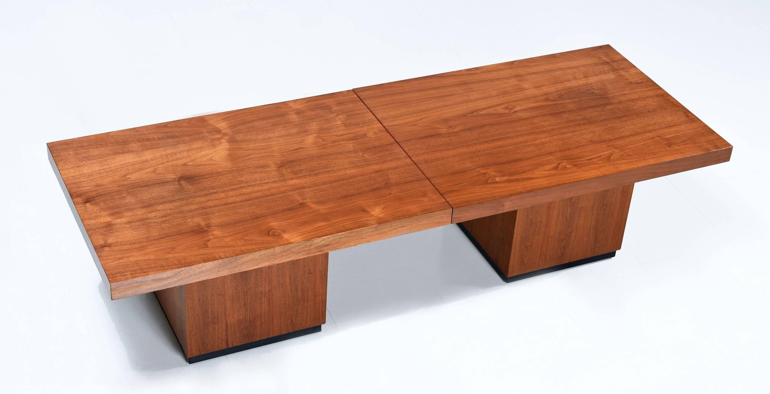 American made, designed by John Keal for Brown Saltman. Handsome, sculptural, masculine expanding walnut wood coffee table. Black laminate tabletop is revealed at centre upon expansion. This table is ideal for those who love to entertain. Use this