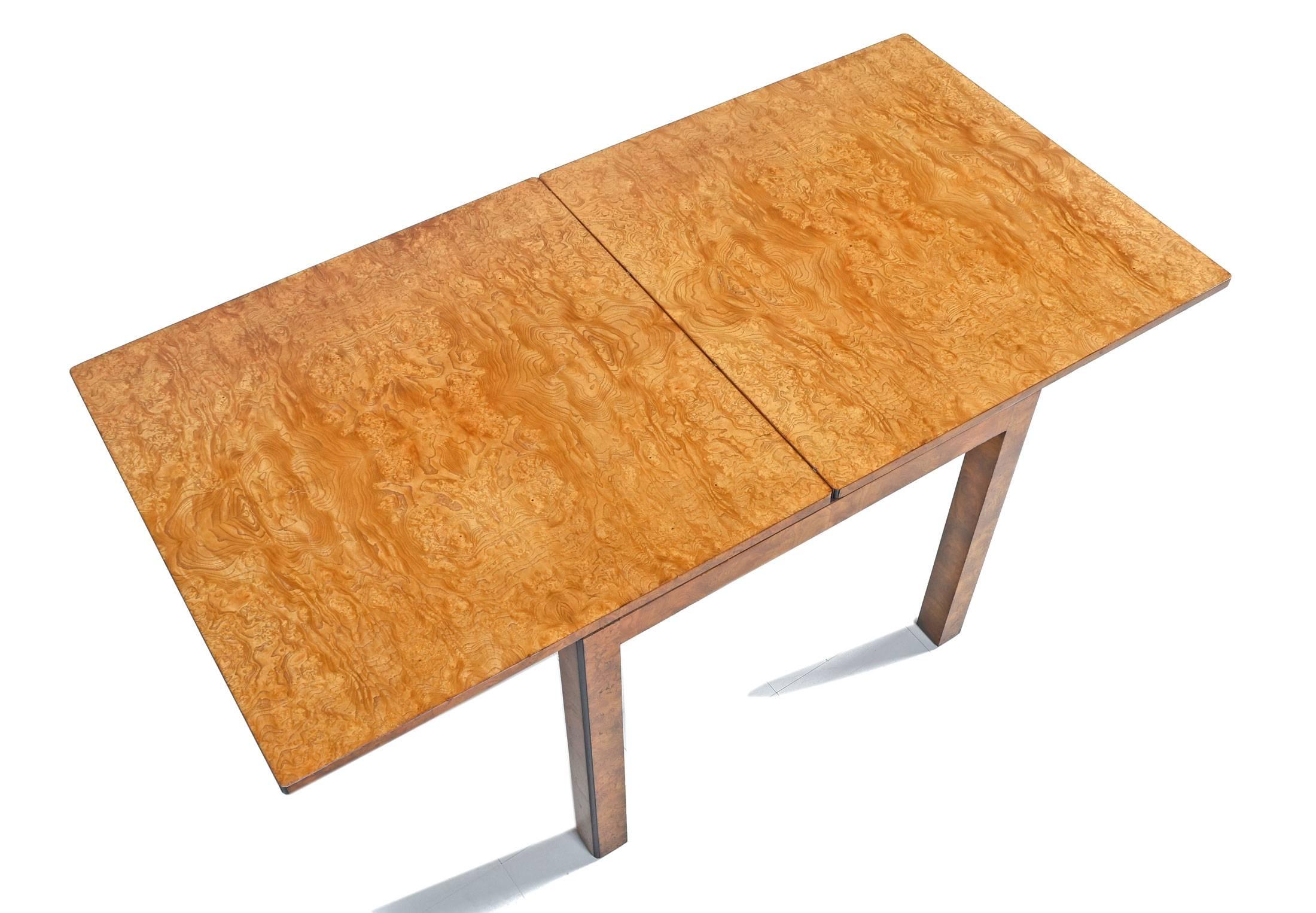 Stunning extendable Parsons style flip-flop dining table by John Widdicomb. Made of a gorgeous golden olive burl wood, circa 1970s. Open fully, the double tabletop extends to creates a large rectangle which hangs past the table base and legs. To