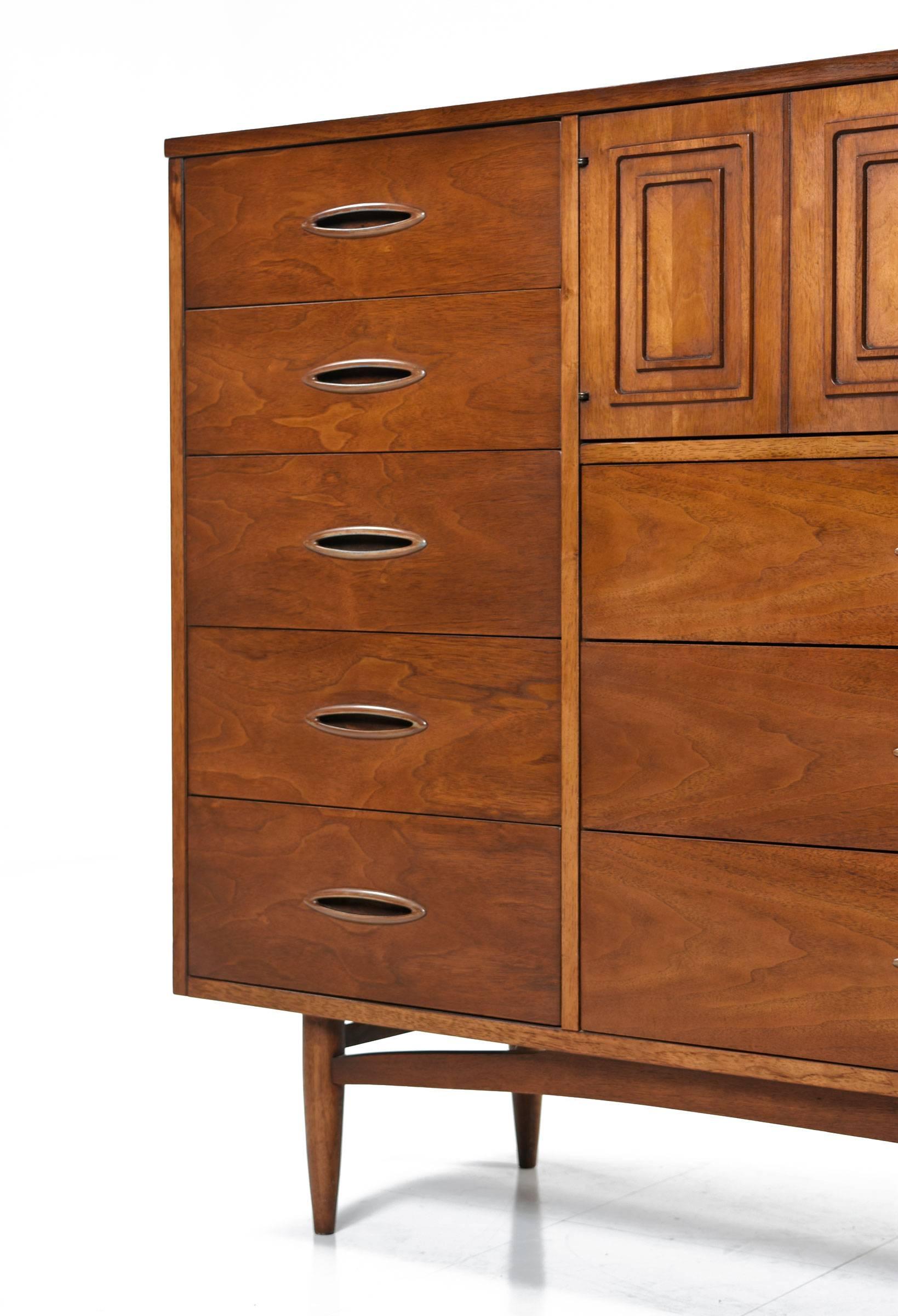 Deep, dark, chocolaty brown patina to the walnut wood. This huge magna dresser is like having a standalone closet and dresser in one. The top row features a cabinet with three divided compartments. The right side has a column of five deep drawers.