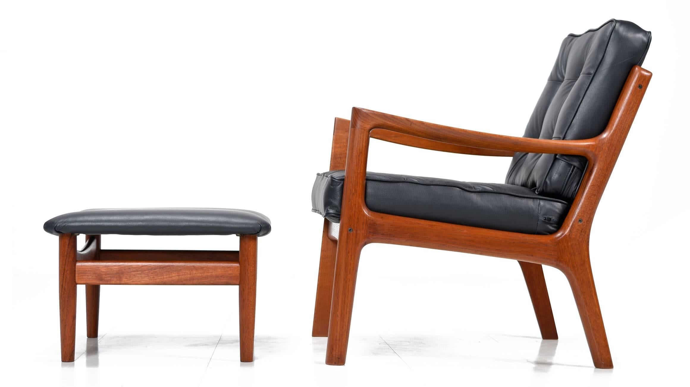 Ole Wanscher easy chair model #166, from the Senator series, by France & Son. This stunning Mid-Century Modern teak and black leather armchair and ottoman feature clean lines and architectural details. It was made in 1951 in Denmark.