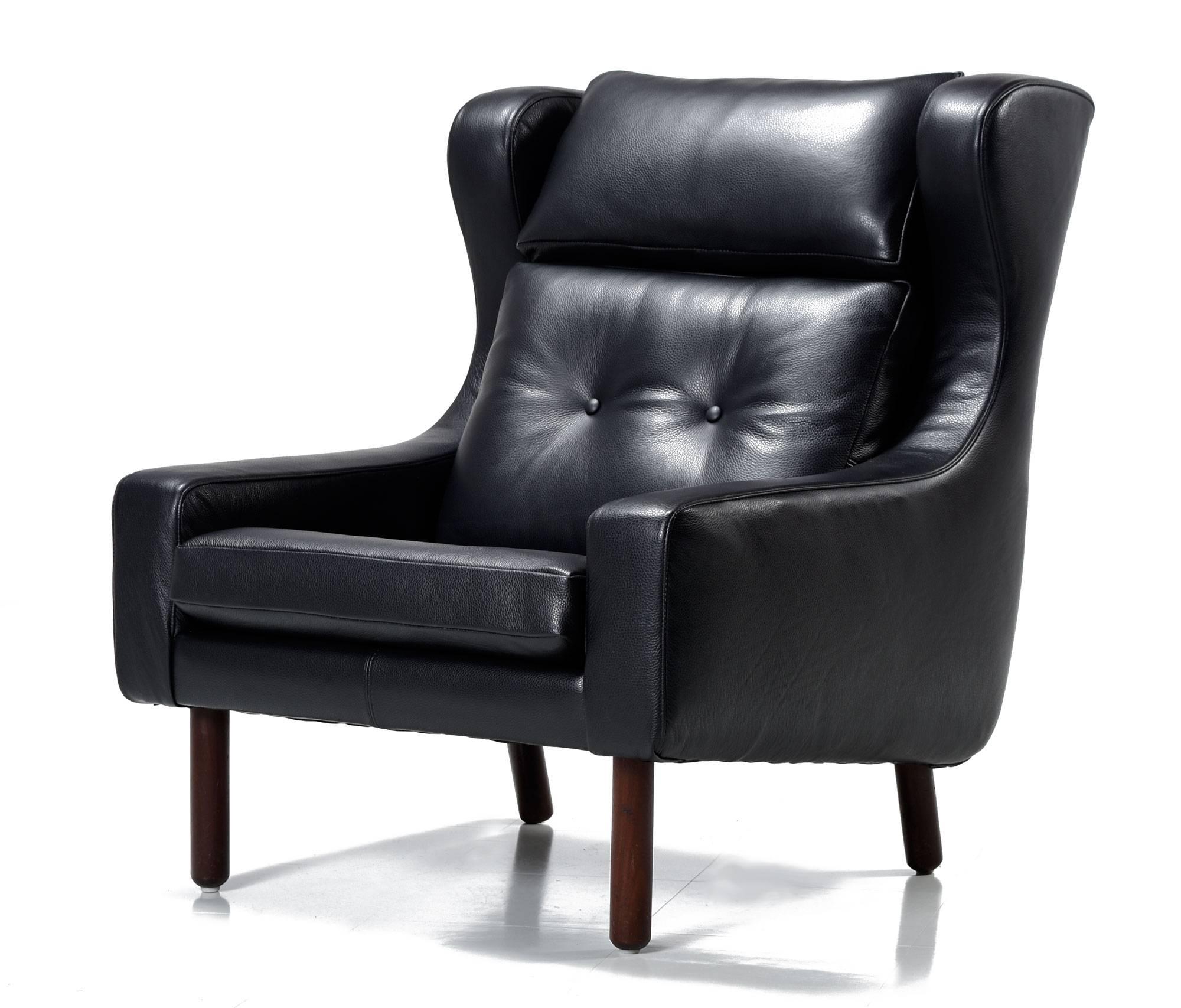 Luxurious pair of black leather Mid-Century Modern 'His & Her' armchairs. These chairs had no marking, but they are clearly in the style of Frits Henningsen and Svend Skipper, made in the 1960s. The larger chair has a wingback style, high back and