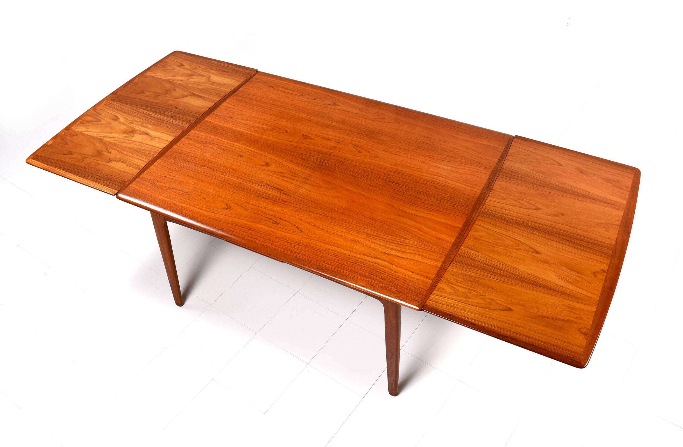 Gorgeous and versatile Arne Vodder teak draw leaf extendable dining table, made in Denmark, circa 1950s. Beautifully aged teak with rich golden patina, quality craftsmanship and exquisite design. This draw leaf dining room table features crescent