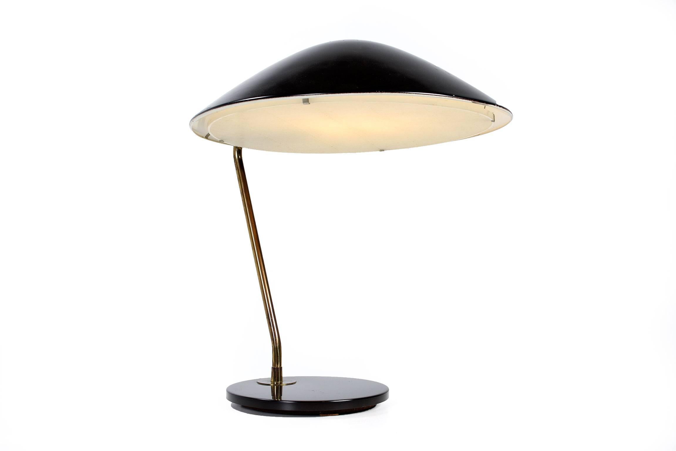 Mid-Century Modern black enamel and brass table or desk lamp designed by Gerald Thurston for Lightolier in the 1950s. It's made of black enameled metal featuring a brass stem, and the original plastic diffuser. This handsome Classic adds design and