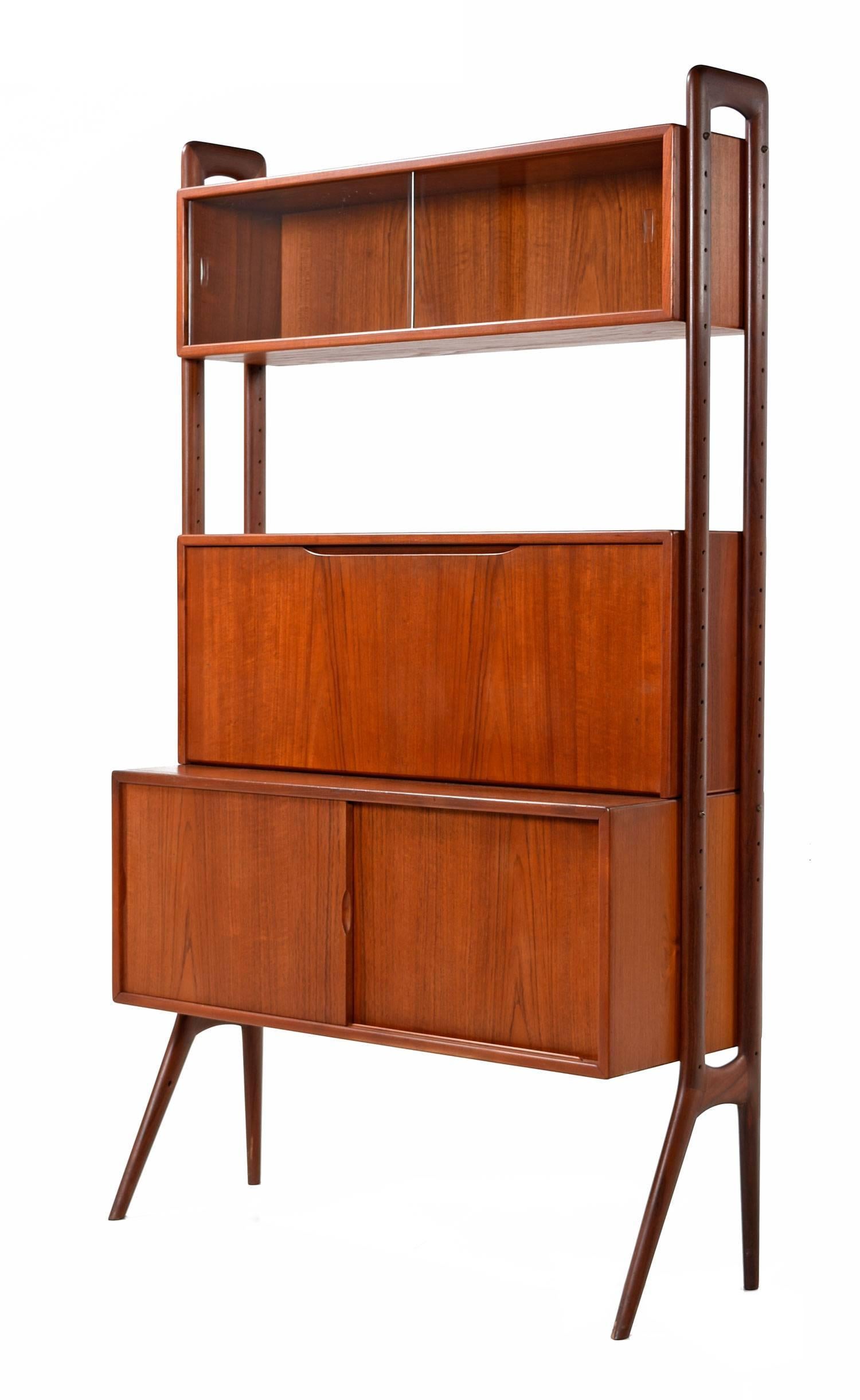 Gorgeous Scandinavian Modern open modular teak wall unit room divider by Kurt Ostervig. Features three adjustable cabinets, one sliding double door large cabinet with a movable shelf, a smaller glass front sliding door cabinet and a medium sized