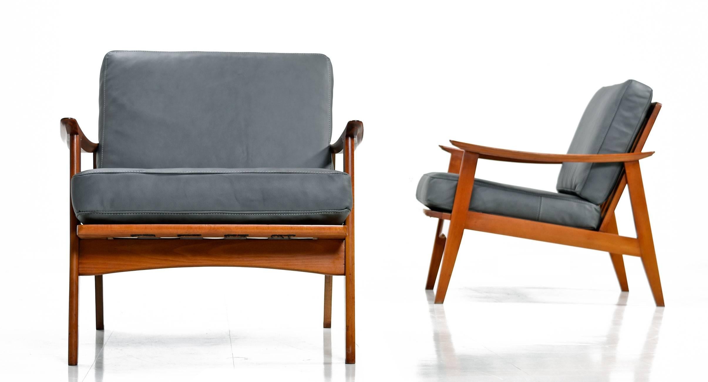 Handsome pair of Mid-Century Modern armchairs made in Yugoslavia. Vintage 1960s, these chairs have been updated with all new top grain gray leather upholstery. Minimalist clean lines give these chairs a captivating Silhouette from all vantages. The