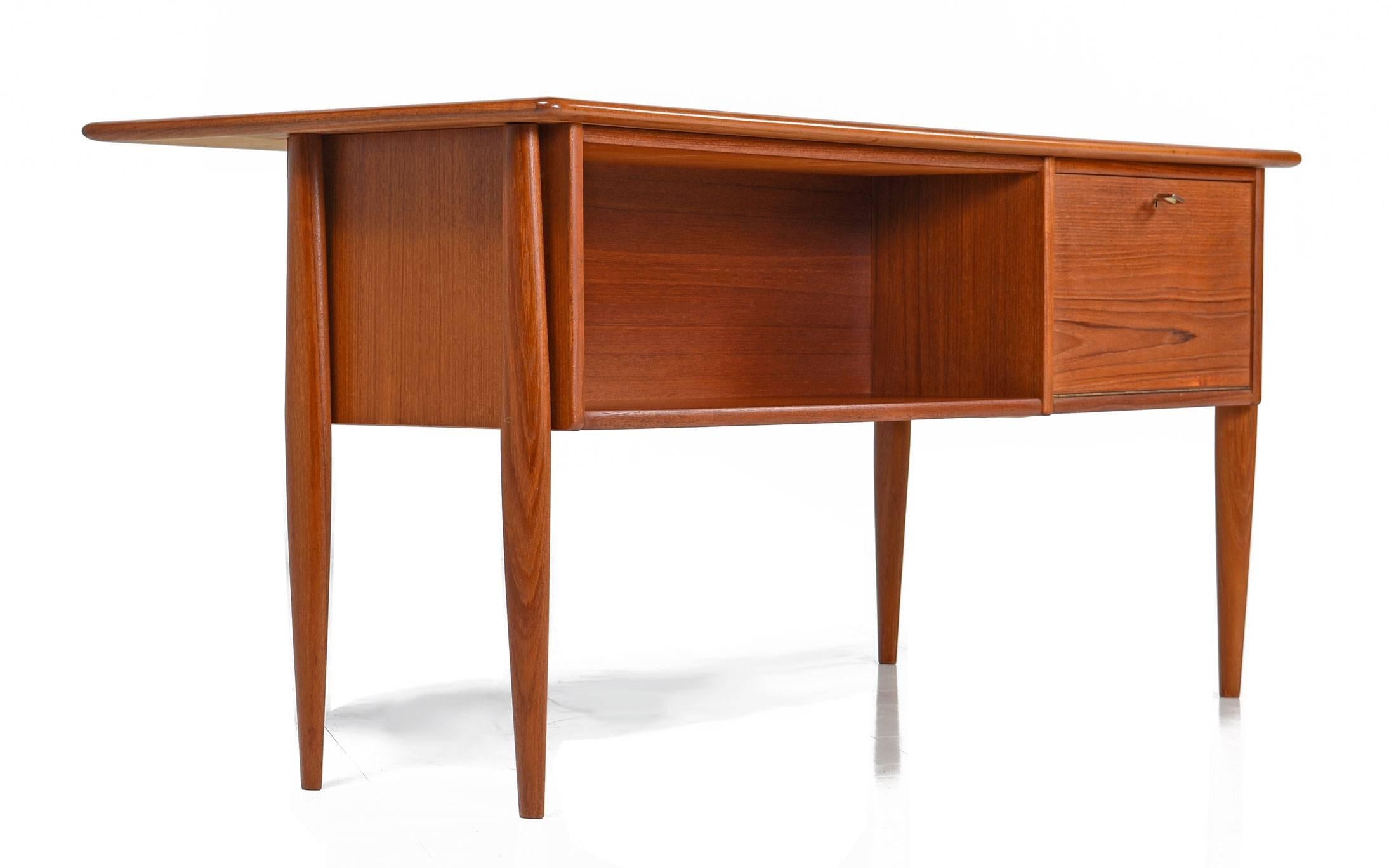 Beautifully restored Scandinavian Modern teak desk, made in the 1960s. This rare and unique desk is two sided, finished on both sides, making it a real stunner from all angels. The front of the desk features a left-hand column of three drawers with