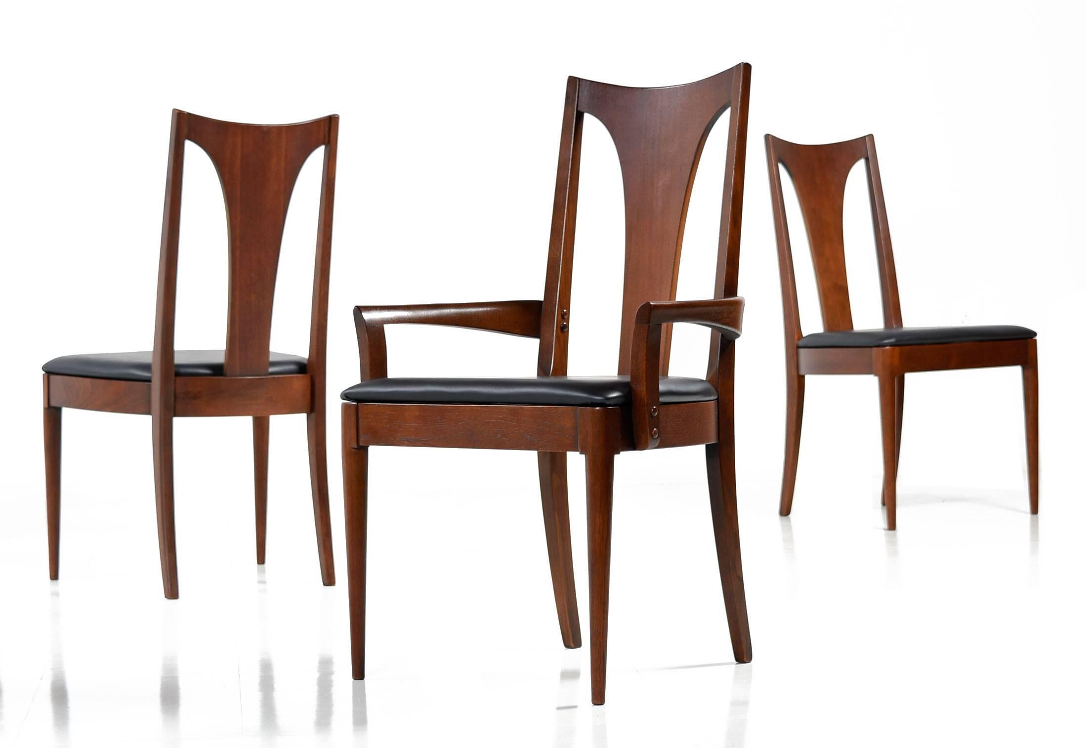 Set of eight Mid-Century modern dining chairs from Boyhill's Saga collection. This set includes seven armless side chairs and one captain's chair with arms. Each chair has been restored with new black vinyl upholstery on the seats, the frames have