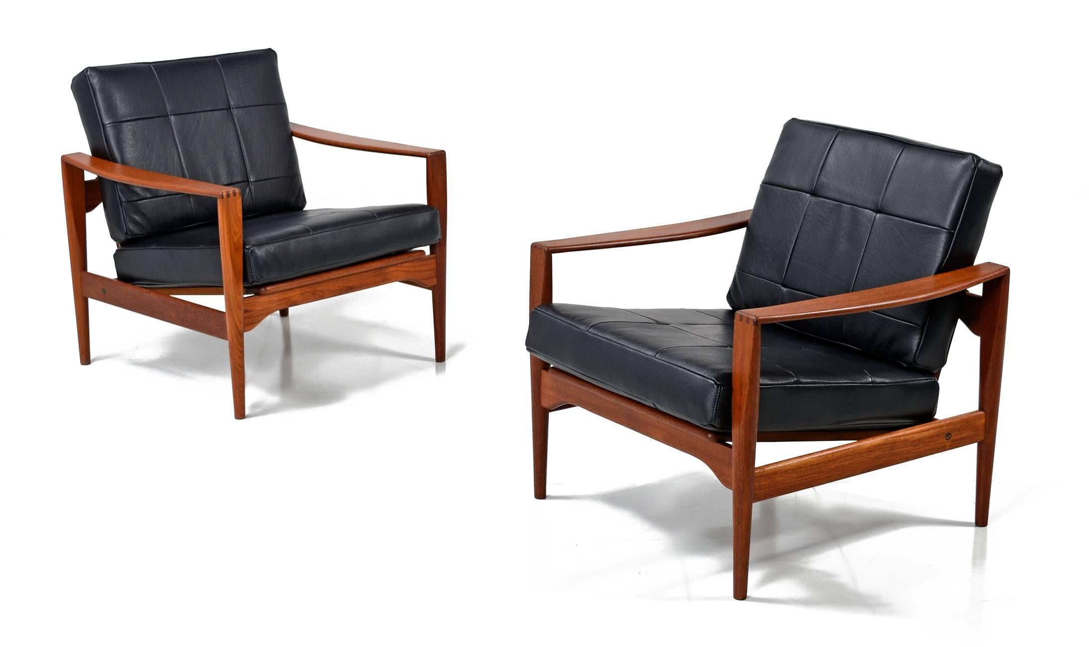 Beautifully restored pair of Mid-Century Modern Kai Kristiansen arm chairs, made for Feldballe Møbelfabrik in Denmark, 1960s. This stunning set are made of teak, featuring exposed finger joints and open framing. The seats have been newly upholstered