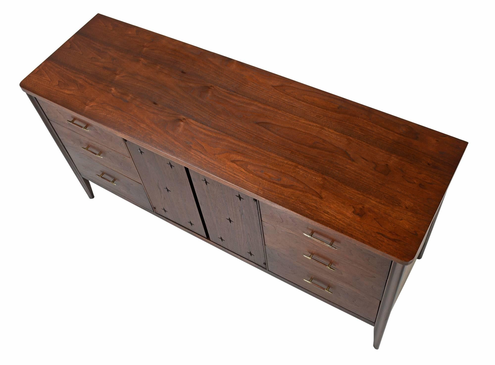 Beautifully restored Mid-Century Modern Broyhill saga triple dresser. One of the most celebrated lines of the Mid-Century Modern Broyhill premier series. The saga triple dresser is made of walnut, and features the distinctive star pattern and Danish