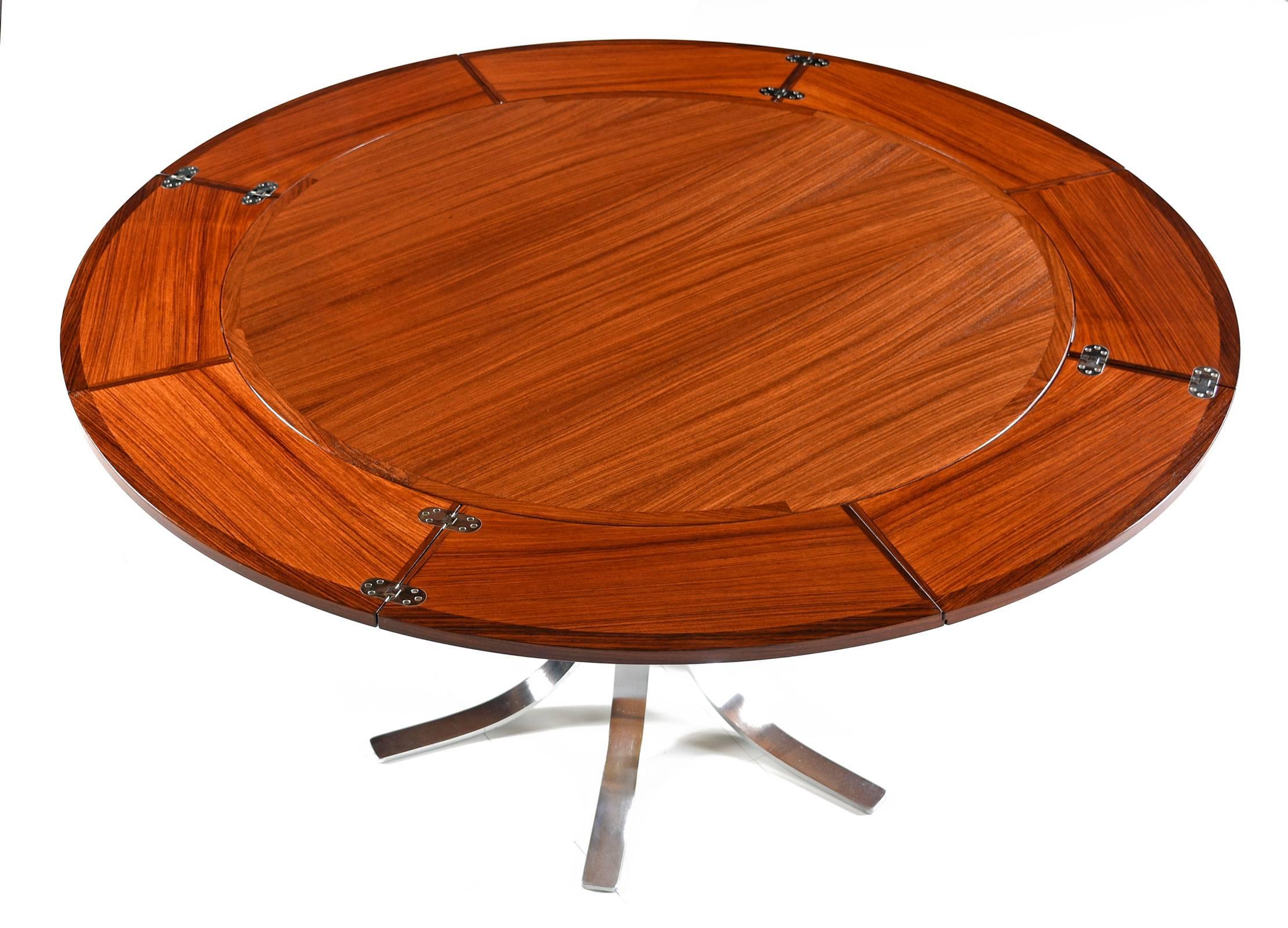 Stunning heirloom quality Mid-Century Modern flip flap table by Dyrlund. Made in Denmark with luxurious rosewood tabletop and sleek chromed steel pedestal base. The table bears the original maker's mark beneath the tabletop. What makes this table so