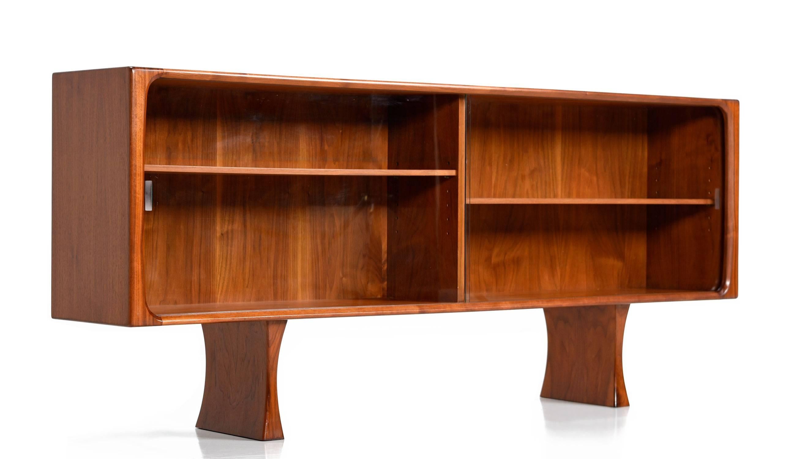 Mid-Century Modern low profile Danish teak bookcase by Bernhard Pedersen & Son. Exceptional quality construction. Elegantly contoured solid teak banding enhances the perimeters. Two bay design with a single adjustable height shelf on each side.