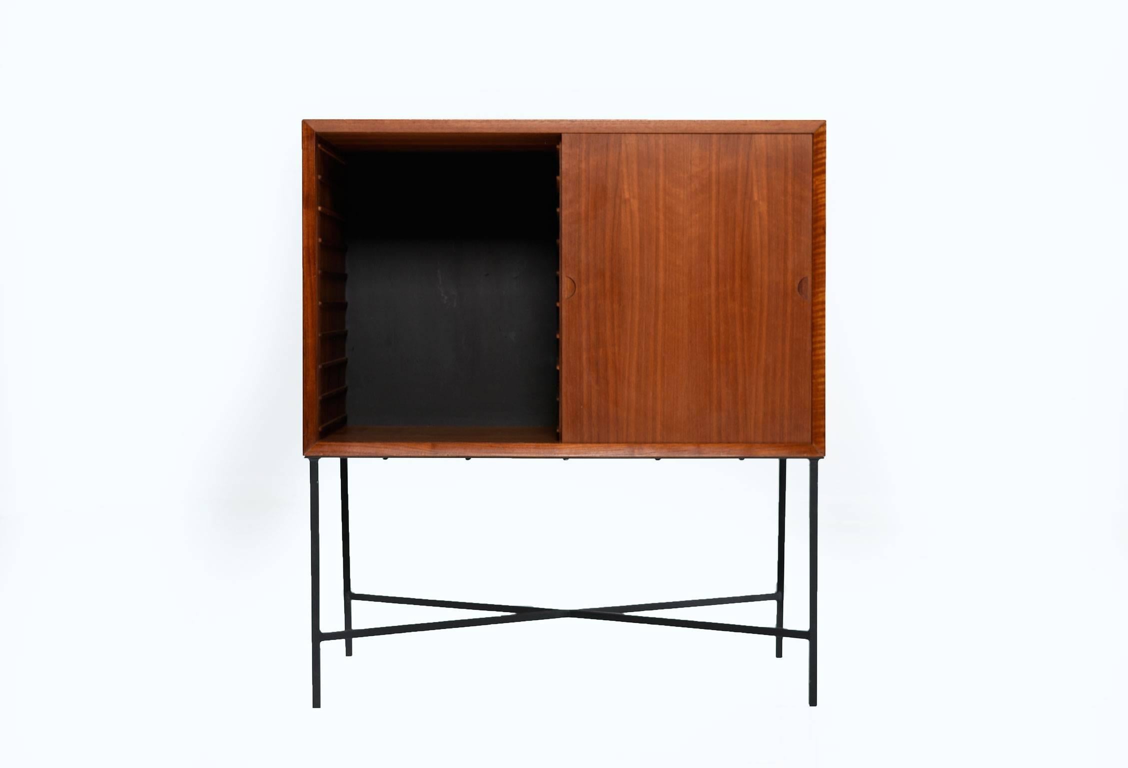 Sleek Mid-Century Modern teak record cabinet mounted on a custom-made, welded, wrought iron base. This teak record cabinet features sliding doors with Classic Danish modern half moon recessed pulls, opening to reveal two large open storage cabinets.