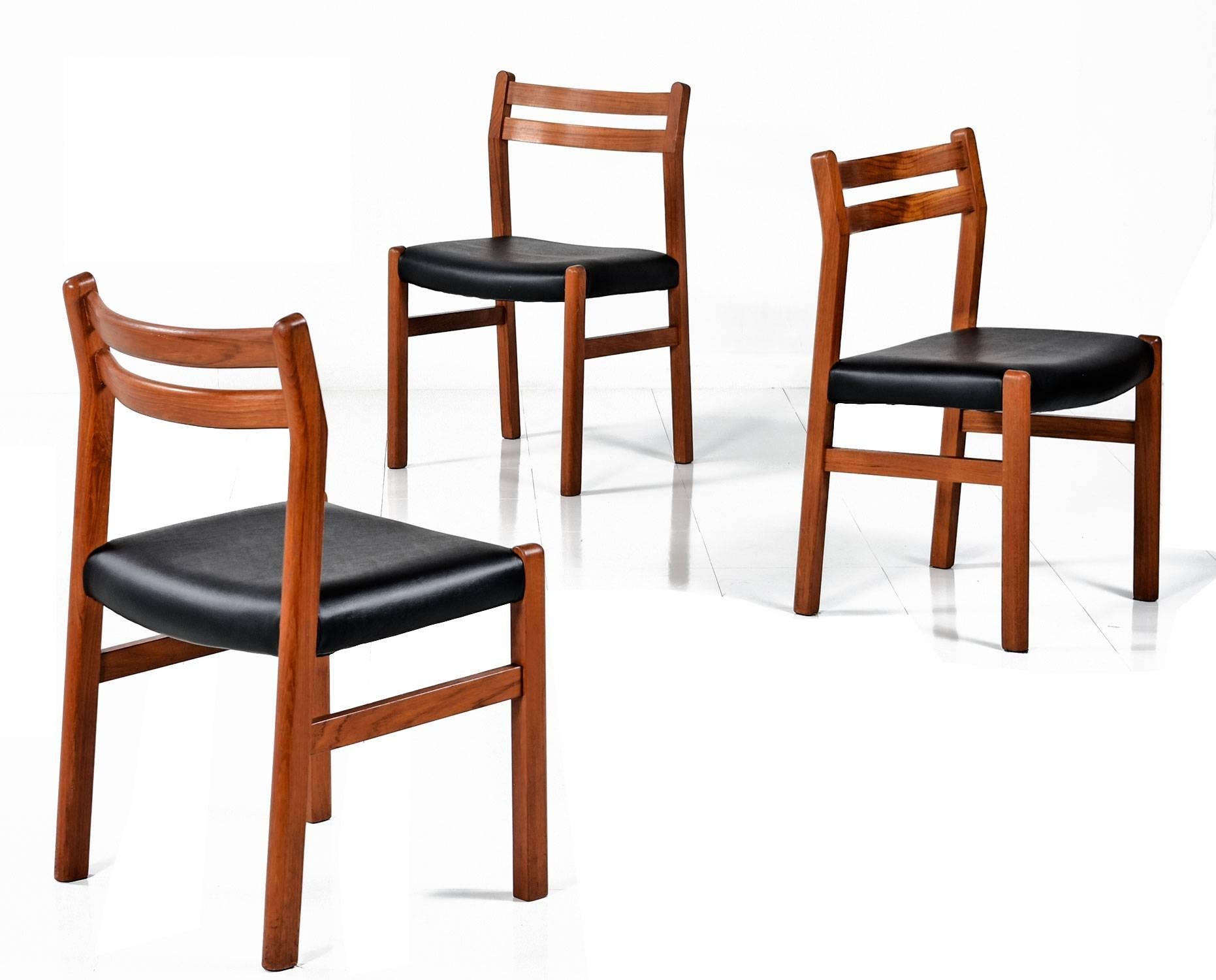 Set of six solid teak vintage Danish modern dining chairs. The quintessential Scandinavian design features a Minimalist approach with two contoured lateral spanners to support the back. The seats have been updated with new high quality black vinyl