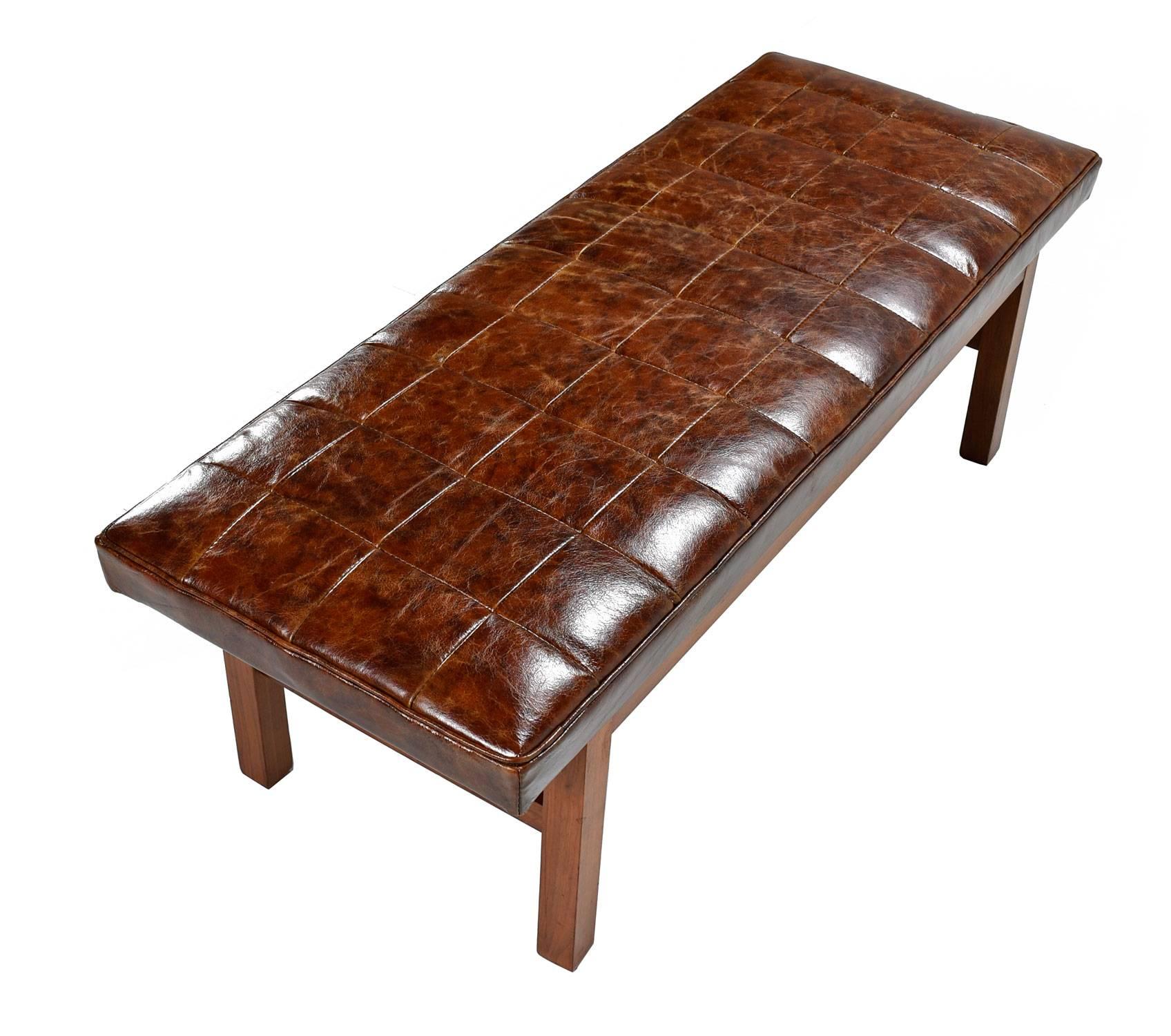 Mid-Century Modern Jens Risom style bench outfitted with new distressed leather upholstery. The quilted pattern adds an heir of esteem to the rich authentic leather hide. The frame is solid walnut wood, American made, vintage 1950s.