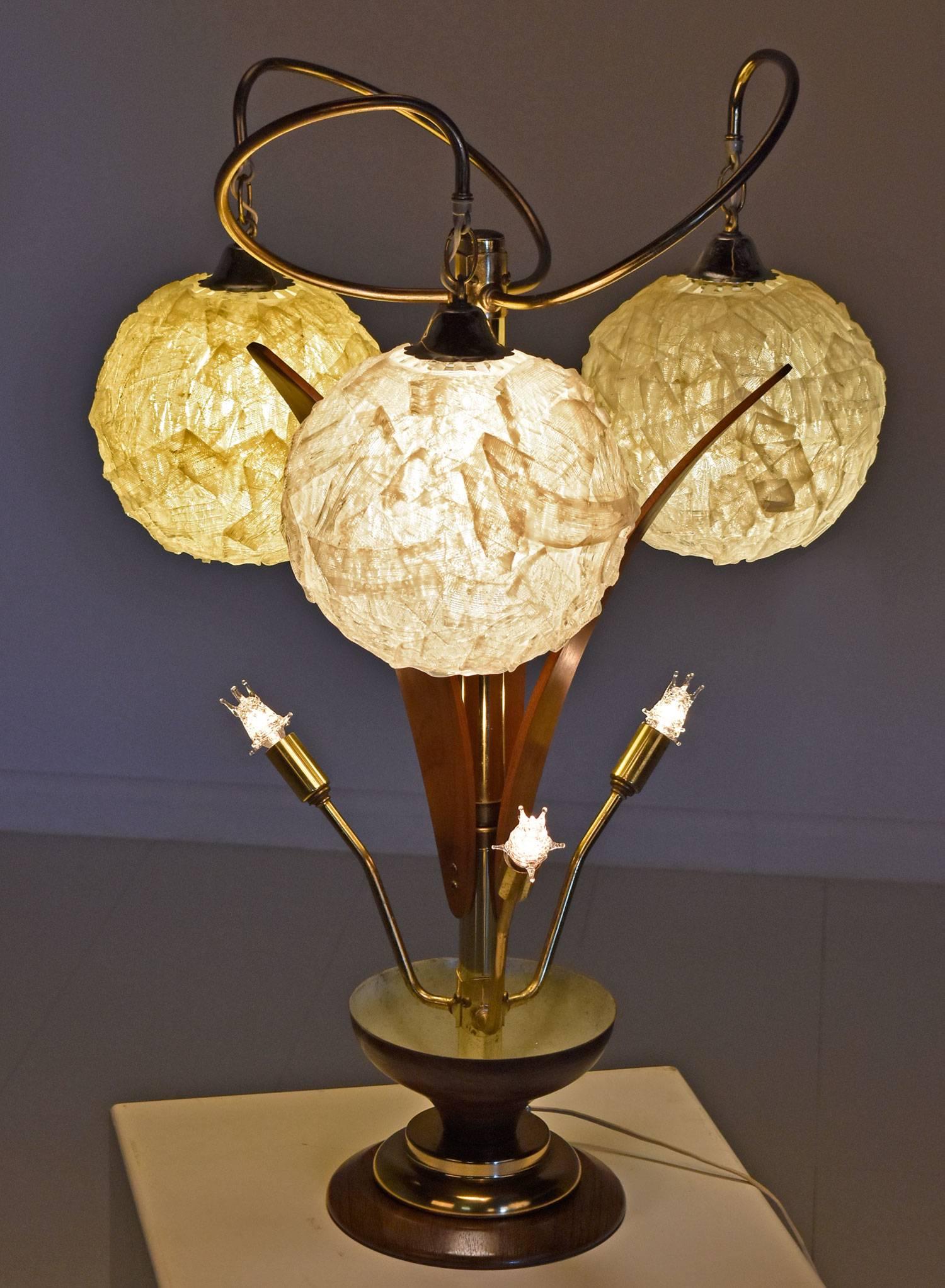 Stunning Mid-Century Modern spaghetti Lucite lamp with three globes and walnut accents. This lamp is oozing atomic age charm! Look at the swirling gold rods supporting the three goopy Lucite globes hovering above a bed of Sputnik spotlights. The