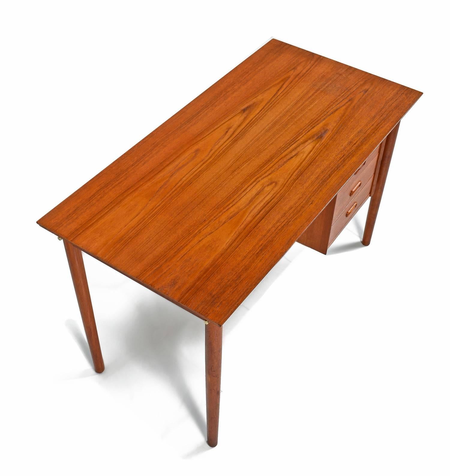 Mid-Century Modern Danish teak desk by Arne Vodder. This vintage desk exhibits clever Scandinavian design with an adjustable column of drawers. Slide the stack of drawers to the left or right side of the desk to suite your comfort. The Minimalist