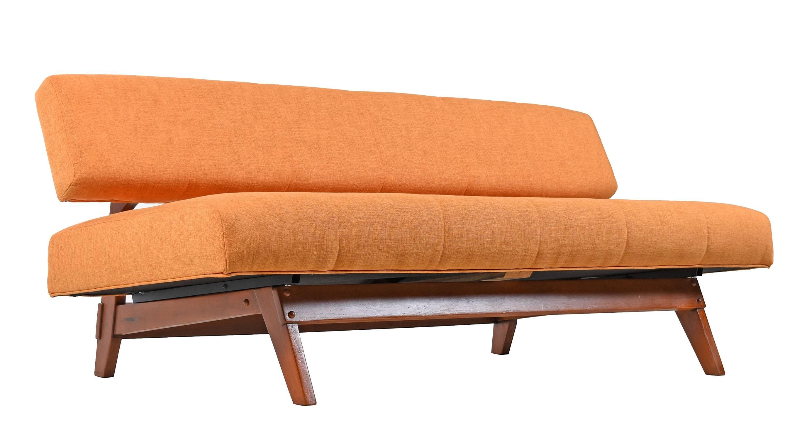 Restored Mid-Century Modern daybed sofa, vintage 1950s. This authentic retro sofa has been completely restored with new foam, and new internal wood backrest beneath the new tangerine colored upholstery. The sofa is convertible. Lift the bottom level